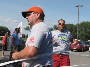 The 'KGB Reunion Tour,' consisting of Dean Patterson, left, and Scott Thompson, cross the finish line to win the 10th annual Chatham-Kent Amazing Race at the Links of Kent Golf Club in Chatham.