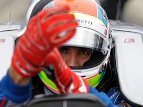 This is a May 14, 2015, file photo showing Justin Wilson, of England, putting on his gloves as he prepares to drive during practice for the Indianapolis 500 auto race at Indianapolis Motor Speedway in Indianapolis. The British driver was in a coma in critical condition after sustaining a head injury when he was hit by a large piece of debris that broke off another car in the crash-filled race at Pocono Raceway on Sunday, Aug. 23, 2015. (AP Photo/Michael Conroy, File)