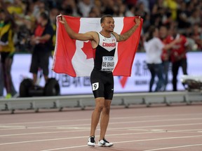 Andre De Grasse poses with a Canadian flag after tying for third in the 100m in 9.93 during the IAAF World Championships in Athletics at National Stadium in Beijing on Aug. 23, 2015. (Kirby Lee/USA TODAY Sports)