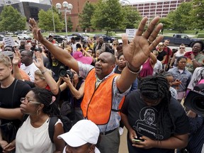 Protesters pray at the federal courthouse in downtown St. Louis August 10, 2015 almost one year after the shooting of Michael Brown in Ferguson, Missouri. Brown was shot and killed by a Ferguson police officer on August 9, 2014. A new municipal judge ordered sweeping changes to court practices in response to a scathing Justice Department report of the shooting. REUTERS/Rick Wilking