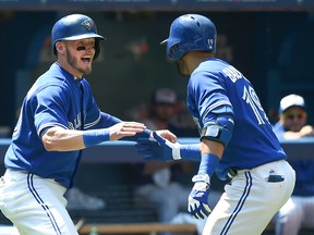 Toronto Blue Jays right fielder Jose Bautista (19) is greeted by third baseman Josh Donaldson (20) after hitting a two-run home run against New York Yankees in the third inning at Rogers Centre.  Dan Hamilton-USA TODAY Sports