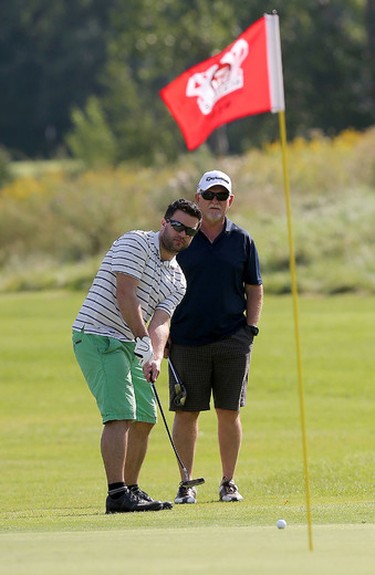 Michel Parent putts from off the green with his partner Joffre Dupuis looking on during the Ottawa Sun Scramble City Championship at Manderley On The Green in Ottawa Monday Aug 24, 2015. Monday's golfers took part in the D division draw. Tony Caldwell/Ottawa Sun/Postmedia Network