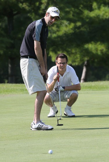 Adam Brennan tries to make a put with his partner Jeremy Kirk watching the break during the Ottawa Sun Scramble City Championship at Manderley On The Green in Ottawa Monday Aug 24, 2015. Monday's golfers took part in the D division draw. Tony Caldwell/Ottawa Sun/Postmedia Network