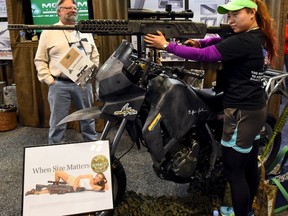 Grace G. looks at a rifle in the trade booth showroom during the National Rifle Association's annual meeting in Nashville, Tennessee April 12, 2015.  The NRA sued Seattle on Monday over a new tax on firearms and ammunition sales. REUTERS/Harrison McClary