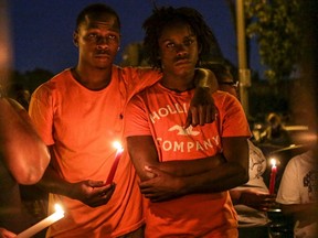 James Cody (L) and his cousin Dennis Ball-Bey attend a candlelight vigil for Mansur Ball-Bey in St. Louis, Missouri on August 20, 2015. The St. Louis police fatally shot Mansur Ball-Bey, a black teenager who they say pointed a gun at them, and later faced angry crowds on August 19. REUTERS/Lawrence Bryant