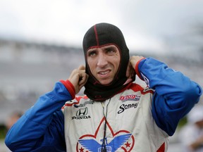 In this July 6, 2013, file photo, Justin Wilson, of England, pulls on his balaclava during a qualifying session for the Pocono IndyCar 400 in Long Pond, Pa. (AP Photo/Mel Evans, File)