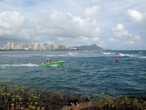 A boat maneuvers out to sea near Point Panic in Honolulu, Monday, Aug. 24, 2015. Tropical Depression Kilo moved farther away from the main Hawaiian Islands on Monday after moisture associated with the system dumped heavy rain on the state. Heavy rain caused wastewater to spew from manholes near the popular tourist destination of Waikiki, said Markus Owens, a spokesman for the state Department of Environmental Services. (AP Photo/Cathy Bussewitz)