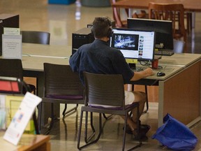 A man watches an American news report online at Western University?s D.B. Weldon Library in London Monday. (DEREK RUTTAN, The London Free Press)