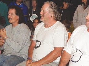 Terry Nelson, Rick Nelson and Steve Wessman wait their turn to get their hair clipped to raise money for afflicted family members.