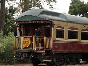 In this June 2, 2011 file photo, a couple takes pictures at the back of the Napa Valley Wine Train as it makes its way through St. Helena, Calif.  (AP Photo/Eric Risberg, File)