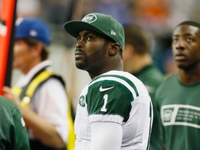 In this Nov. 24, 2014 file photo, New York Jets quarterback Michael Vick looks from the sidelines during the second half of an NFL football game against the Buffalo Bills in Detroit. Nike signed Vick when he was a rookie in 2001, and ended his contract in 2007 after he filed a plea agreement admitting his involvement in a dog fighting ring.  After he served jail time and rejoined the NFL, Nike decided to resign Vick, saying that he had acknowledged his past mistake. (AP Photo/Paul Sancya)