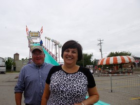 Maria Reis and Bill Killing of the Woodstock Agricultural Society stand in front of  rides being assembled for the upcoming Woodstock Fair that runs August 27 to 30. (HEATHER RIVERS, Sentinel-Review)
