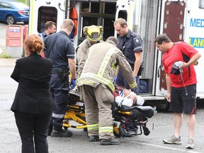 City of Greater Sudbury paramedics and firefighters tend to a pedestrian who was struck by an SUV  at Evergreen and MacKenzie streets in front of Journal Printing on Tuesday. Gino Donato/Sudbury Star/Postmedia Network