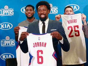 Los Angeles Clippers DeAndre Jordan, middle, the league rebounding champion, is reintroduced at a Staples Center news conference with teammates, forward Branden Dawson, left, and guard Austin Rivers, right, in Los Angeles on July 21, 2015. (AP Photo/Nick Ut)
