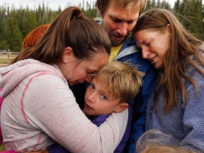 Malachi Bradley, centre, is reunited with his family, Monday, Aug. 24, 2015, in Uintah County, Utah, after being lost near a remote mountain lake near the Wyoming border on Sunday. Also pictured are his mother, Molly Chrisman, left, father, Danny Bradley, top, and grandmother Sharon Clark. (Ravell Call/The Deseret News via AP)