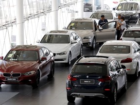 People look around cars at a dealer shop of BMW in Beijing, China, July 13, 2015. (REUTERS/Kim Kyung-Hoon)