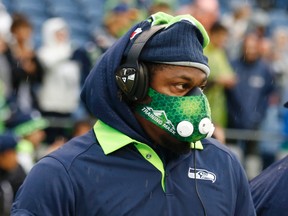 Seattle Seahawks running back Marshawn Lynch wears a high-altitude training mask during warm-ups before the Seahawks' preseason NFL football game against the Denver Broncos, Friday, Aug. 14, 2015, in Seattle. (AP Photo/John Froschauer)