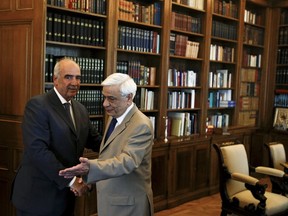 Greek President Prokopis Pavlopoulos welcomes the leader of conservative New Democracy party Vangelis Meimarakis before their meeting in the presidential palace in Athens, Greece, August 21, 2015. Greece's president formally gave the conservative opposition a chance on Friday to form a new government after leftist Prime Minister Alexis Tsipras resigned, but the country appears almost certain to be heading to an election next month. (REUTERS/Stoyan Nenov)