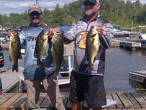 Frank Clark (left) and Mike Desforges show off four of the five monster largemouth bass the team caught on Day 2 to win the Nipissing Challenge last weekend. Photo supplied