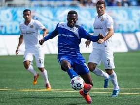 FC Edmonton's Tomi Ameobi (centre) shoots on Fort Lauderdale Strikers' Josh Ford during a NASL soccer game at Clarke Stadium in Edmonton, Alta., on Sunday August 23, 2015. Ian Kucerak/Edmonton Sun/Postmedia Network