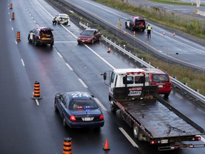 A tow truck driver was in critical condition in hospital after being struck by a car on the Queensway / Hwy 417 near Palladium Dr. Wednesday, August 26, 2015. Witnesses say it was pouring rain when a red Honda lost control and struck the tow truck operator. MIKE CARROCCETTO / OTTAWA SUN / POSTMEDIA NETWORK