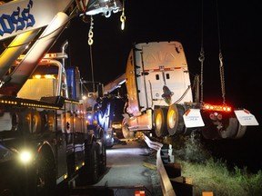 A transport truck rolled into a ditch on Highway 402, the truck, which was hauling 4 industrial generators, left the eastbound lanes of the highway near an interchange with Highway 401, causing the highway to be partially closed while crews worked to clear the scene. (CRAIG GLOVER, The London Free Press)