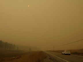 Thick smoke from nearby wildfires makes the sun an orange sphere high in the sky as seen from State Route 20 between Tonasket, Wash., and Republic, Wash., Wednesday, Aug. 26, 2015. (AP Photo/Ted S. Warren)