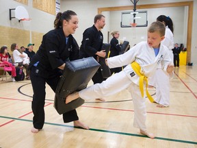 Kids Kicking Cancer sensei Kristin Burns, left, holds a pad for David Kurn, 7, as they participate in the organization's first belt grading ceremony as part of their Hero's Circle community program at the London Lightning gymnasium in London, Ont. on Wednesday August 26, 2015. Nine students have been training with martial artists to use movement and discipline as a way to channel pain and frustration away from their individual illnesses. (CRAIG GLOVER, The London Free Press)