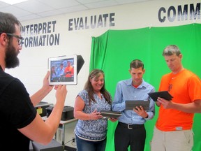 Colin Pattison, left, a Grade 7/8 teacher at Indian Creek Road Public School in Chatham, frames a group of fellow participants in a seminar on ways to use technology more effectively in the classroom, held on Tuesday, Aug. 25 and Wednesday, Aug. 26, 2015 at A.A. Wright Public School in Wallaceburg. Posing in front of a green screen with the iPads they're using are Tara Mitchell, an assistive technology resource teacher, Bryan Cowden, an Apple technician for the Lambton-Kent District School Board, and Mark Stacey, a Grade 7 teacher at King George VI Public School in Chatham. (Don Robinet/ Postmedia Network)