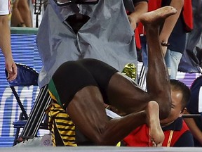 Usain Bolt of Jamaica collides with a cameraman on a segway after the men's 200m final during the 15th IAAF World Championships at the National Stadium in Beijing, China August 27, 2015. REUTERS/Lucy Nicholson