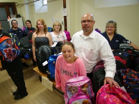 Volunteers handed out knapsacks to school children on Thursday at College Avenue United Church as part of Operation Sharing's Knapsacks for Kids program. From left Brandon Bright, Jake Medeiros, Ellen Hargreaves, Brittany Storey, Jackie Perry, Natalie Shapton, Shawn Shapton and Lucie Thompson. HEATHER RIVERS/WOODSTOCK SENTINEL-REVIEW