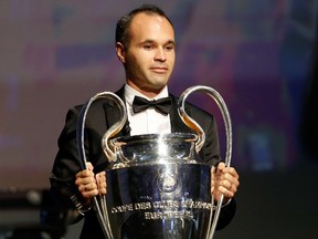 FC Barcelona's captain Andres Iniesta holds the Champions League trophy at the start of the UEFA Champions League Group stage draw ceremony, on August 27, 2015 in Monaco. AFP PHOTO / VALERY HACHE
