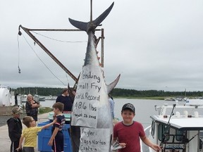 Koen Norton, a 10-year-old boy from Prince Edward Island, poses with a 220-kilogram bluefin tuna he landed off the province's northeastern shore. (THE CANADIAN PRESS/ho-Greg Norton)