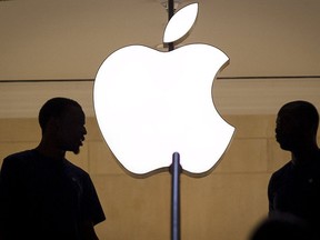 Customers stand beneath an Apple logo at the Apple store in Grand Central station in New York City, July 21, 2015. REUTERS/Mike Segar