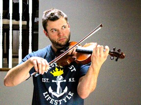 Greg Henry plays a tune on his $5,100 fiddle — a 1927 J.B. Collin— in his home in Corunna. Henry took home the top prize at the 2015 Canadian Grand Masters Championship in Moncton last weekend, earning him the title of Canada's best fiddler. (Chris O’Gorman/ Sarnia Observer)