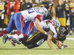 Tiger-Cats’ Zach Collaros gets sacked by Kyries Hebert (34) and Kyler Elsworth (41) of the Alouettes during the first half of last night’s game at Tim Hortons Field in Hamilton. The Alouettes won it, 26-23. (Reuters)