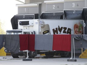 A truck discovered abandoned on an Austrian motorway containing more than 70 bodies sits at a customs building with refrigeration facilities in the village of Nickelsdorf, Austria, August 28, 2015. (REUTERS/Heinz-Peter Bader)