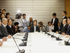 Japanese Prime Minister Shinzo Abe, right, speaks during a cabinet meeting about a Tokyo 2020 Olympic stadium plan in Tokyo Friday, Aug. 28, 2015. (Kazunari Fujikake/Kyodo News via AP)