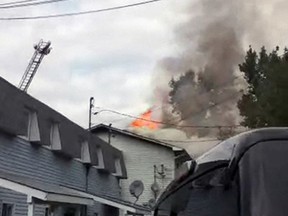 Flames rise from the roof of a four-unit residential building on Yvon-Pichette in Masson Angers Friday afternoon. The fire is believed to have been arson. (Twitter photo via @GoWithItJam)