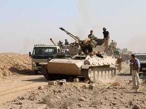 Kurdish Peshmerga fighters sit on top of a tank south of Daquq, north of Baghdad August 26, 2015. Kurdish forces attacked Islamic State insurgents in a cluster of villages in Iraq's northern province of Kirkuk on Wednesday, bent on securing territory they have gained in the course of rolling back the jihadists since last summer.  REUTERS/Stringer