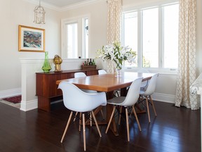 A retro table and sideboard made of gorgeous teak wood is freshened 
up with a set of clean white plastic retro-inspired chairs.