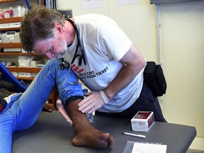 Canadian Doctor Simon Bryant of Doctors Without Borders examines a patient wound from dog bite in Libya on May 14, 2015. (Supplied photo)