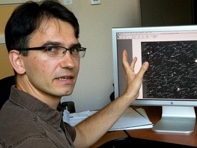 Stanimir Metchev of the Physics and Astronomy department at Western University points out a photograph showing the path and speed of 215 asteroids they found with a new technique, only 59 of these asteroids were previously known. Photographed in London, Ont. on Friday August 28, 2015. (MIKE HENSEN, The London Free Press)