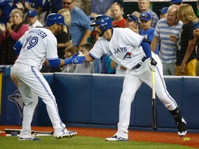 Blue Jays' Jose Bautista (left) is greeted by Chris Colabello (right) after hitting his 31st home run during the fifth inning against the Tigers in Toronto on Friday, Aug. 28, 2015. (Jack Boland/Postmedia Network)