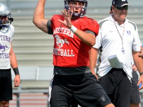 Will Finch, working out in front of coach Greg Marshall recently, is back quarterbacking the powerful Western Mustangs this season. (MORRIS LAMONT, Postmedia Network)