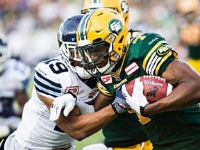 Edmonton's Adarius Bowman (4) is tackled by Toronto's Devin Smith (19) during a CFL game in Edmonton, Alta. on Aug. 28, 2015. (CODIE McLACHLAN/Postmedia Network)
