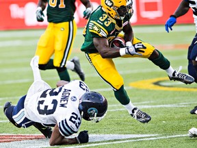 Edmonton running back Shakir Bell takes to the air after being tackled by Toronto’s Vincent Agnew during Friday’s game at Commonwealth Stadium. (Codie McLachlan, Edmonton Sun)