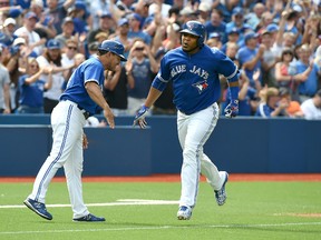 Toronto Blue Jays designated hitter Edwin Encarnacion, right, is greeted by third base coach Luis Rivera as he heads for home after hitting a grand slam home run against the Detroit Tigers in the seventh inning at Rogers Centre. (Dan Hamilton-USA TODAY Sports)