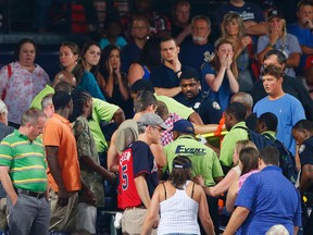 Rescue workers carry an injured fan from the stands at Turner Field during a baseball game between Atlanta Braves and New York Yankees Saturday, Aug. 29, 2015, in Atlanta. The fan was given emergency medical treatment and taken to a hospital after falling from the upper deck into the lower-level stands. (AP Photo/John Bazemore)