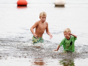 OTTAWA - Aug 29, 2015 - Alex Fortier, 12, splashes his little cousin Liam Lalonde, 4, while playing in the beach area at Petrie Island Park Saturday, Aug. 29, 2015.
MATT DAY / OTTAWA SUN